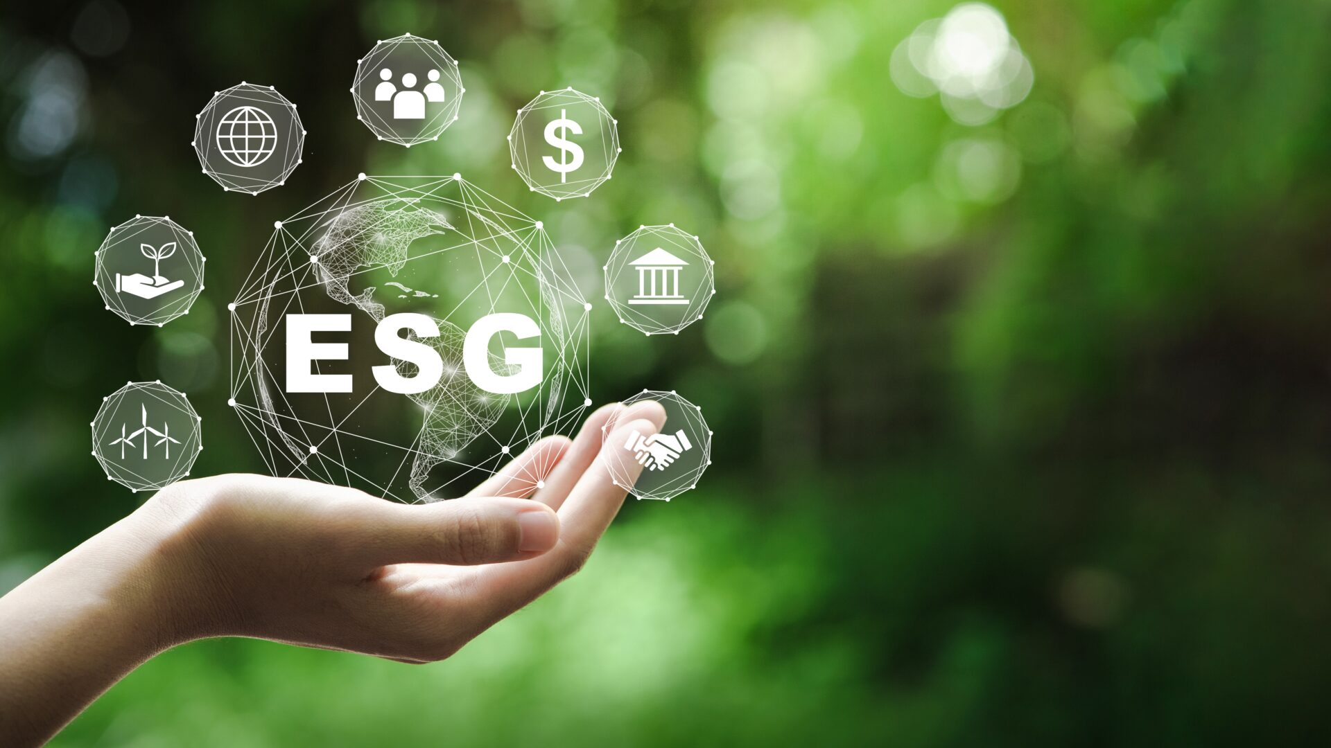 Main tenant des symboles ESG sur fond de verdure